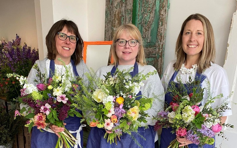 Three ladies holding flowers