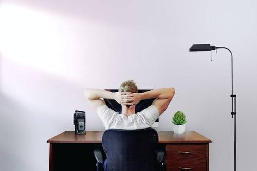 back view of a man sitting at a desk